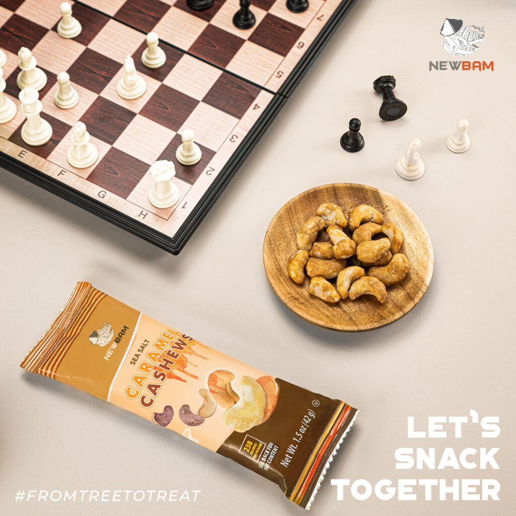 Sea Salt Caramel cashews beside a chessboard and a NEWBAM pouch.