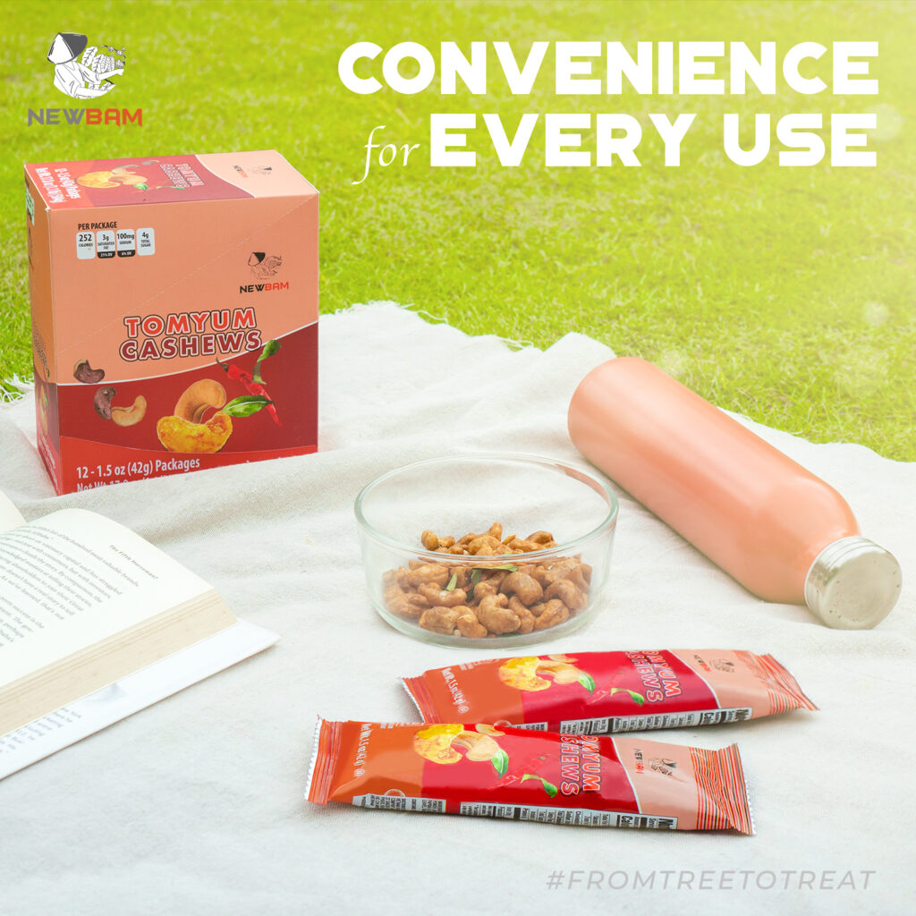NEWBAM Tom Yum box, pouches and cashews on a picnic blanket; Tom Yum is one of the Party Mix flavors.