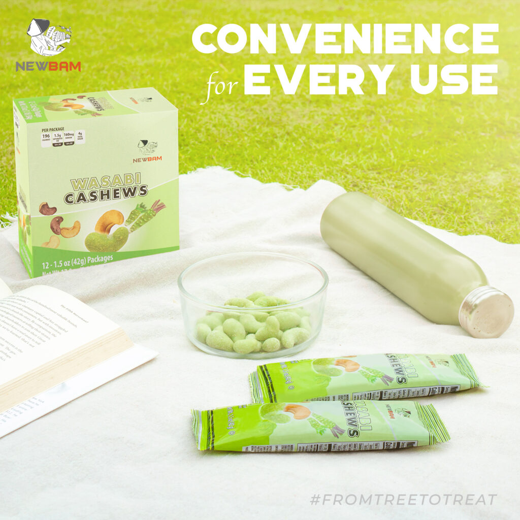 NEWBAM Wasabi box, pouches and a bowl of green-coated cashews on a picnic blanket.